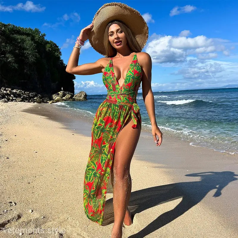 Woman in vibrant green and red floral print two piece set with straw hat, perfect beach outerwear