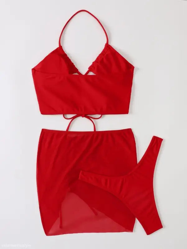 Red three piece bikini featuring ruched design and tie straps for stylish summer vibes
