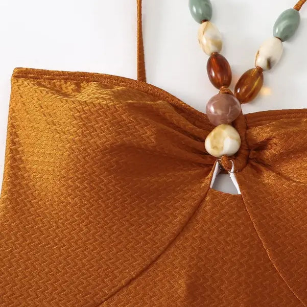 Textured brown top with beaded straps featured on a wine red jumpsuit