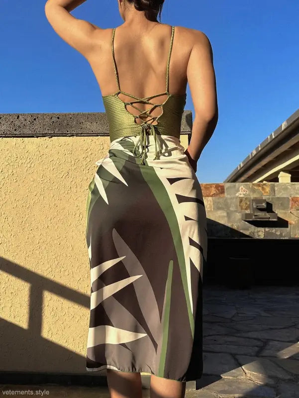 Woman wearing a green jumpsuit and tropical-print sarong, showcasing summer style