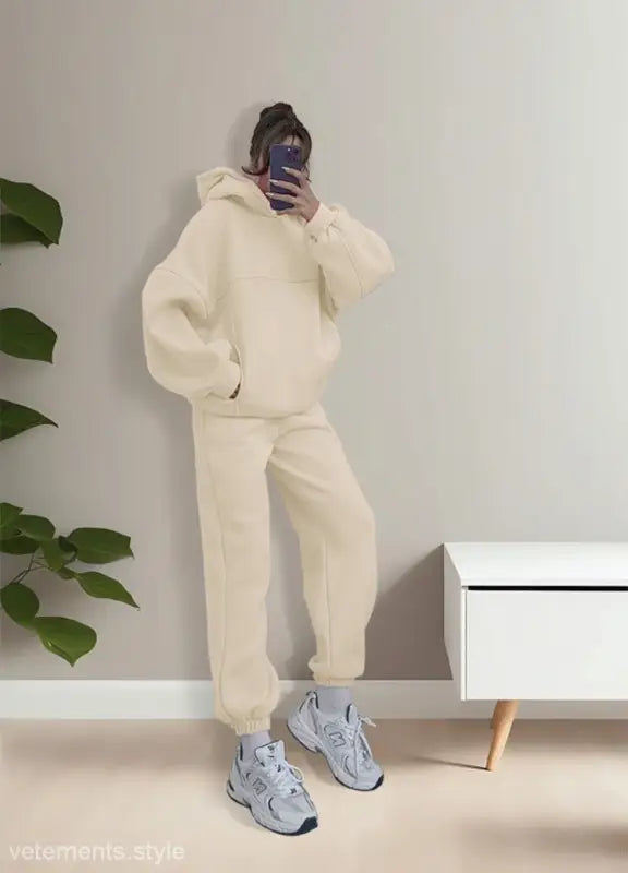 Person wearing casual comfy sweaters two piece winter solid color outfit with gray sneakers