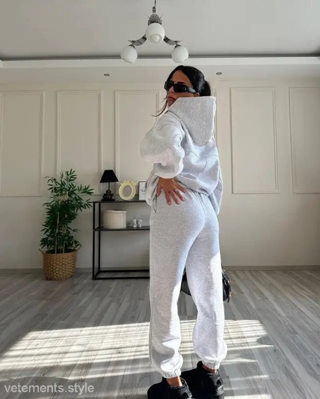 Woman in casual comfy sweaters two piece winter solid color hoodie set with sunglasses