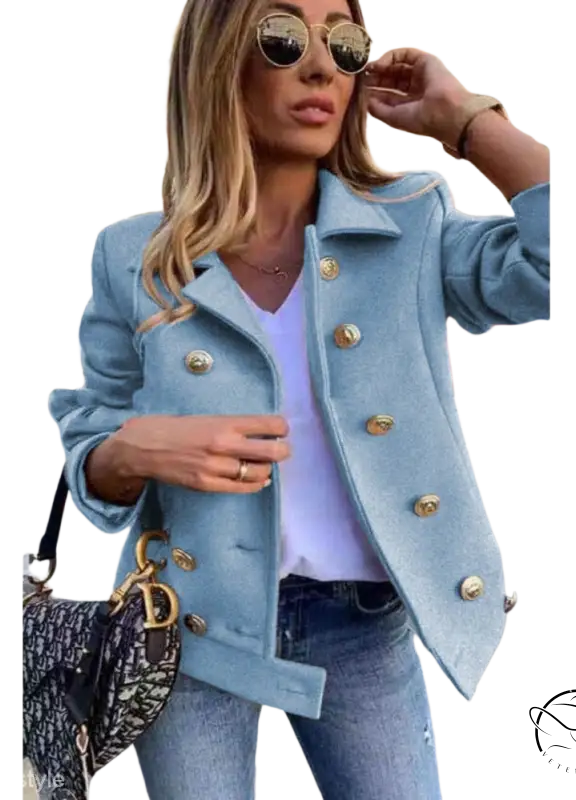 Light blue double breasted jacket with gold buttons over white top and jeans