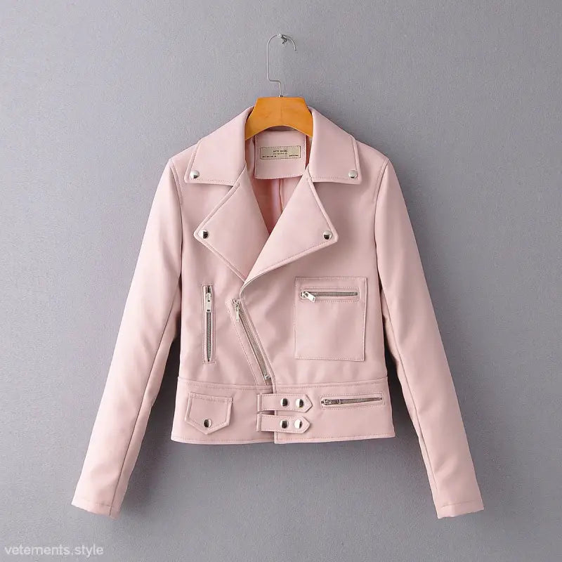 Pale pink faux leather biker jacket hanging on a wooden hanger for fall/winter style