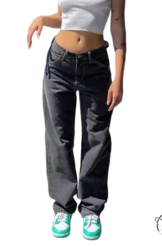 Person in white crop top, wide leg light blue jeans, and green sneakers