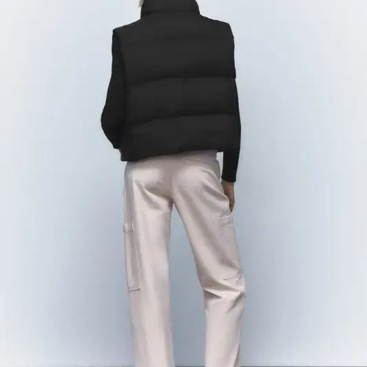 Woman’s black puffer vest paired with light pink pants for autumn winter short jacket