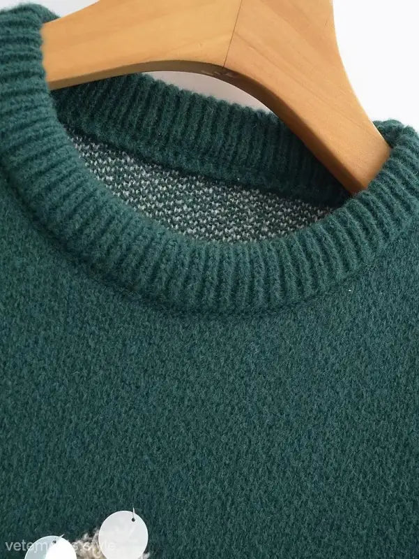 Green knit sweater on wooden hanger, perfect deer holiday sweater for Christmas festivities