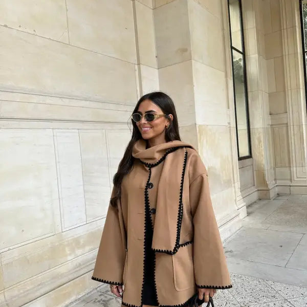Stylish beige contrast scarf woolen coat with black trim worn by a woman with sunglasses