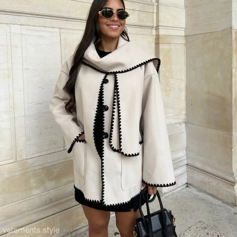 Stylish white coat with black trim and decorative stitching, ideal for a contrast scarf woolen coat ensemble