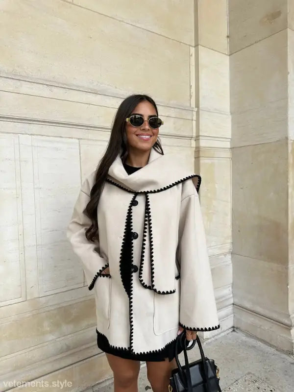 White coat with black trim and decorative stitching, ideal for contrast scarf woolen coat outfits