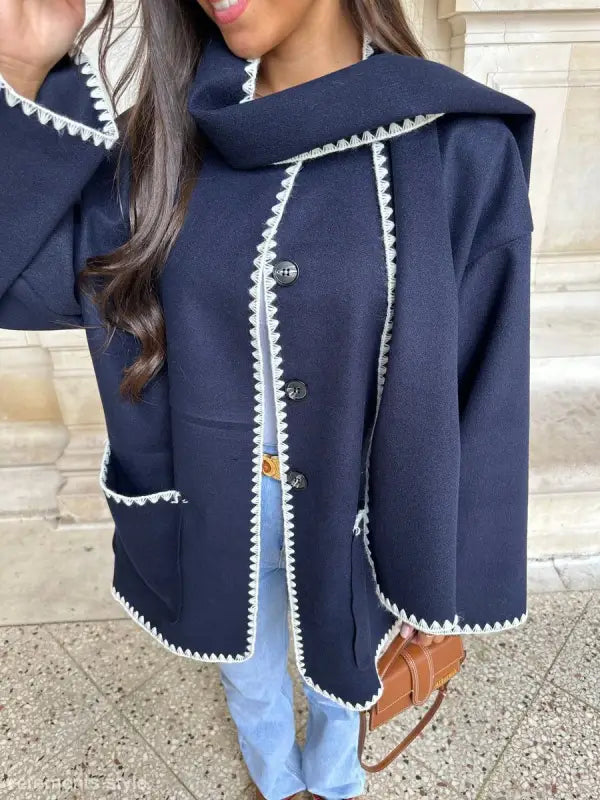 Navy blue jacket with white trim and button closure paired with contrast scarf woolen coat