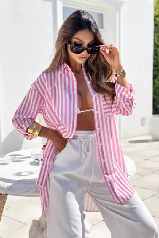 Woman wearing casual mid length shirt dress with pink and blue stripes and pockets