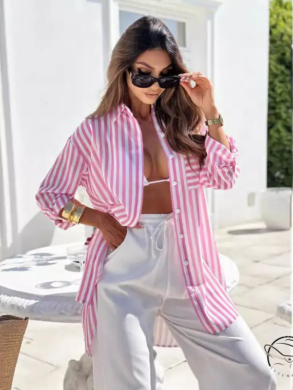 Woman wearing casual mid length shirt dress with pink and blue stripes and pockets