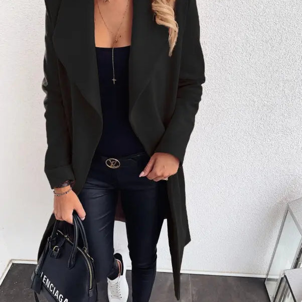 Black trench coat over dark outfit with white sneakers and Balenciaga handbag