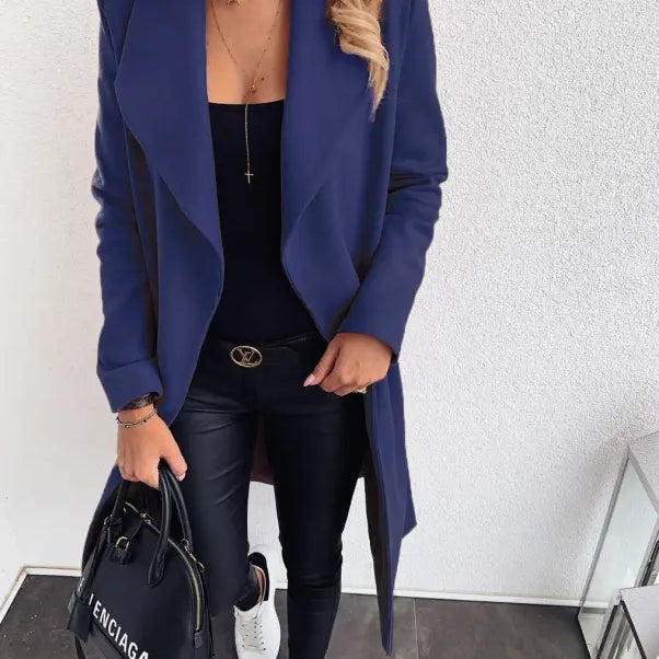 Navy blue trench coat over black outfit featuring white sneakers and Balenciaga handbag