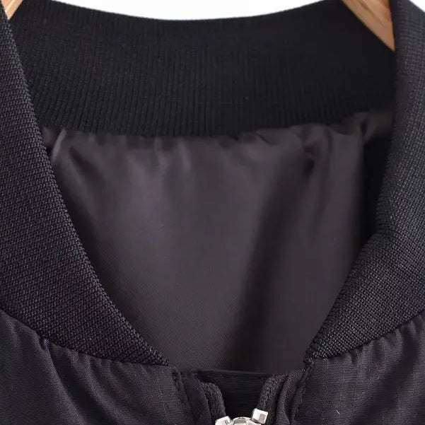 Black short bomber jacket with pocket and tie stand collar on wooden hanger