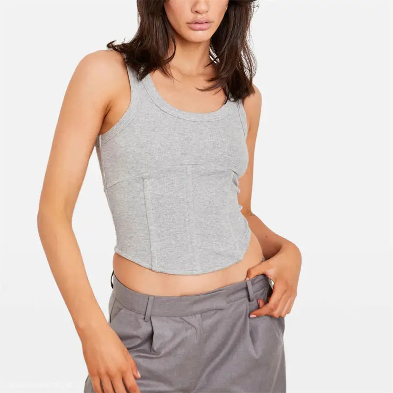 Woman wearing gray ribbed boning corset tank top with pleated trousers for casual summer style