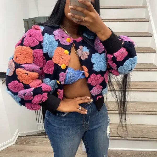 Rose red Chrysanthemum floral print bomber jacket with pom-poms and denim jeans on black background