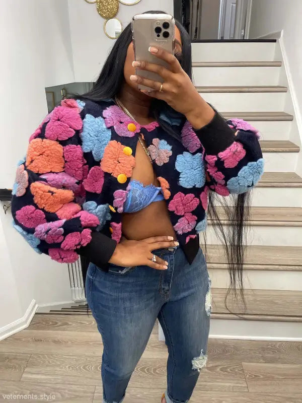 Rose red Chrysanthemum floral print bomber jacket with pom-poms and denim jeans on black background
