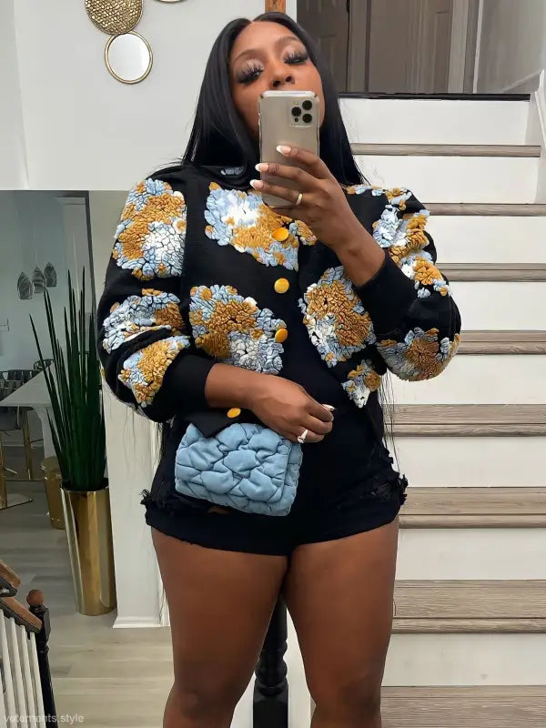 Rose red Chrysanthemum floral print jacket with blue quilted leather purse on black background