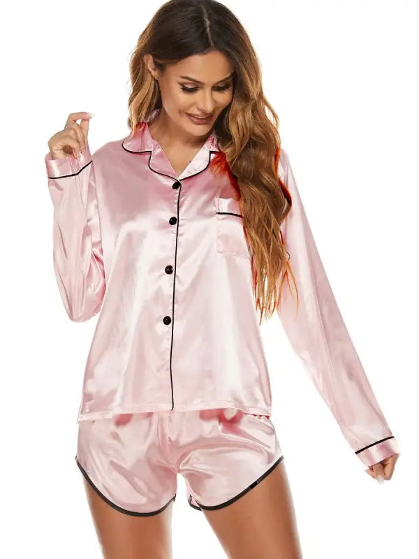 Pink satin silk shorts pajamas with black piping, featuring long-sleeve button-up top