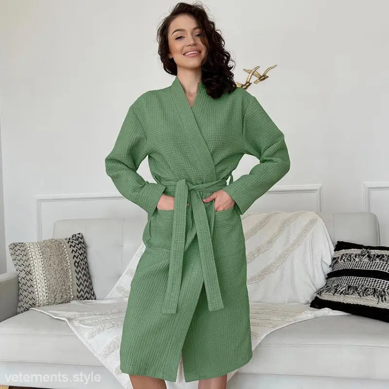 Green textured waffle long robe with belt and pockets worn by smiling woman