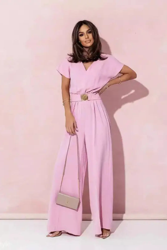 Woman wearing coral red casual trousers jumpsuit with short sleeves and wide-leg pants