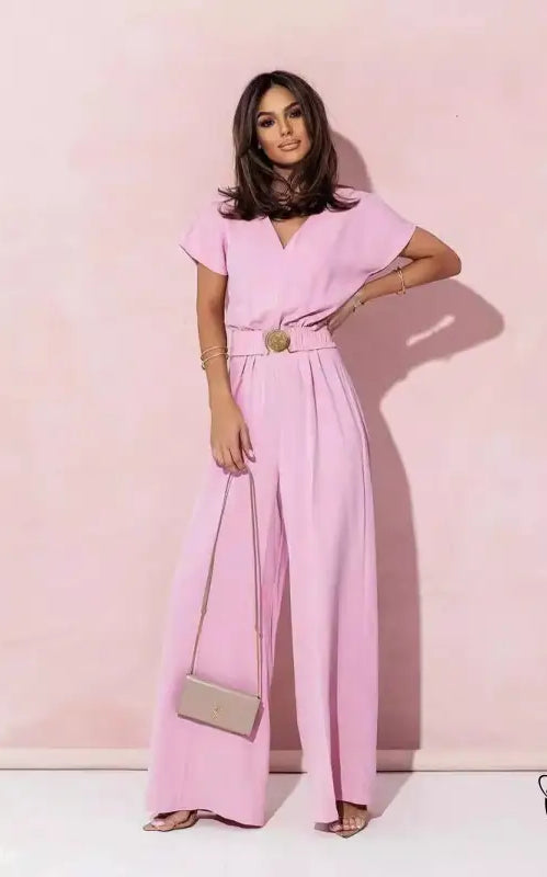 Woman in coral red casual trousers jumpsuit with belt and wide-leg pants