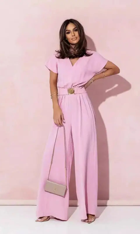 Woman wearing coral red casual trousers jumpsuit with short sleeves and wide-leg pants