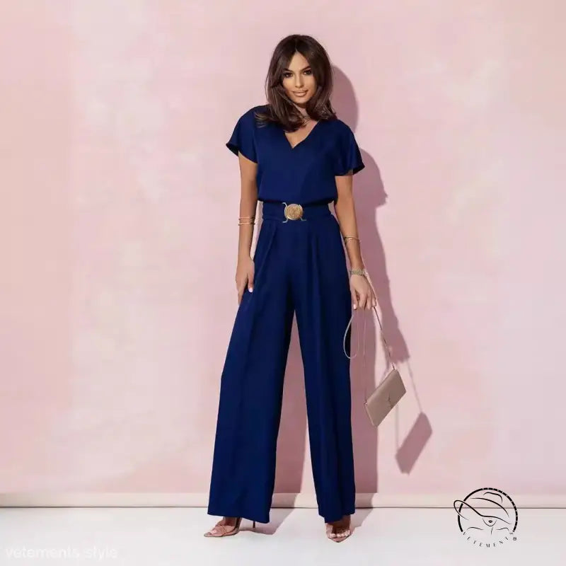 Woman in navy blue casual trousers jumpsuit with belt and short sleeves