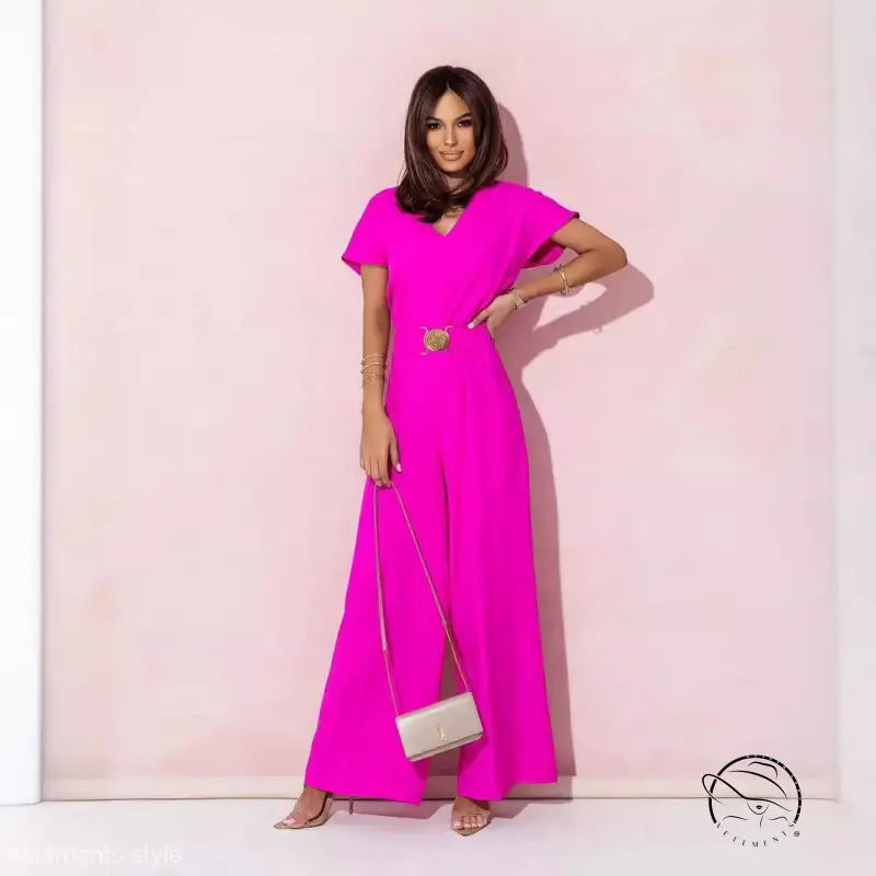 Woman in coral red casual trousers jumpsuit with gold belt and clutch