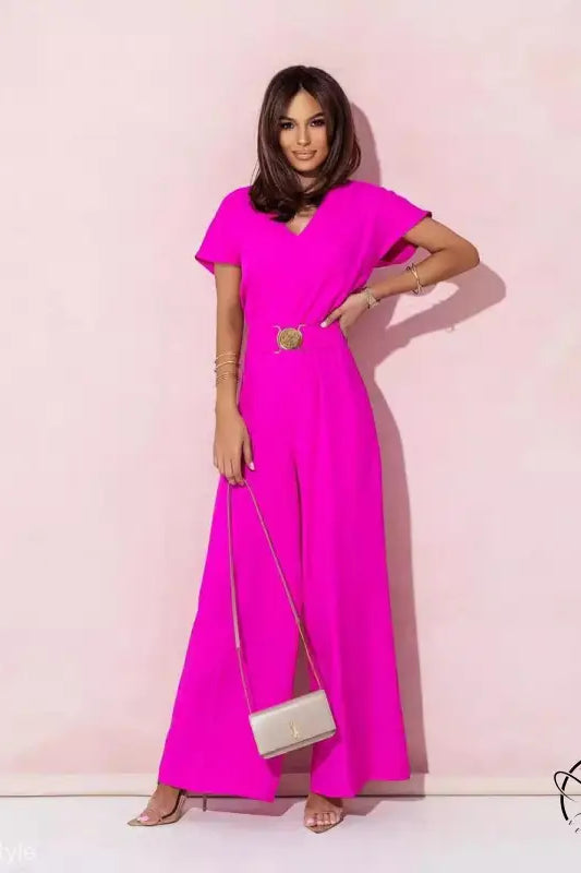 Woman in coral red casual trousers jumpsuit with short sleeves, gold belt, and clutch purse