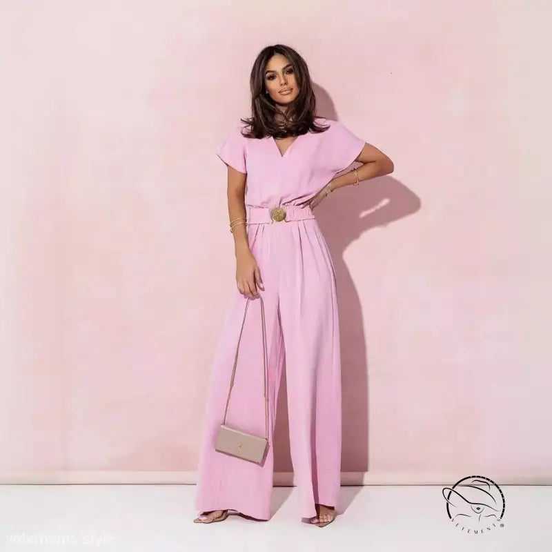 Woman in coral red casual trousers jumpsuit with wide-leg pants and belted waist