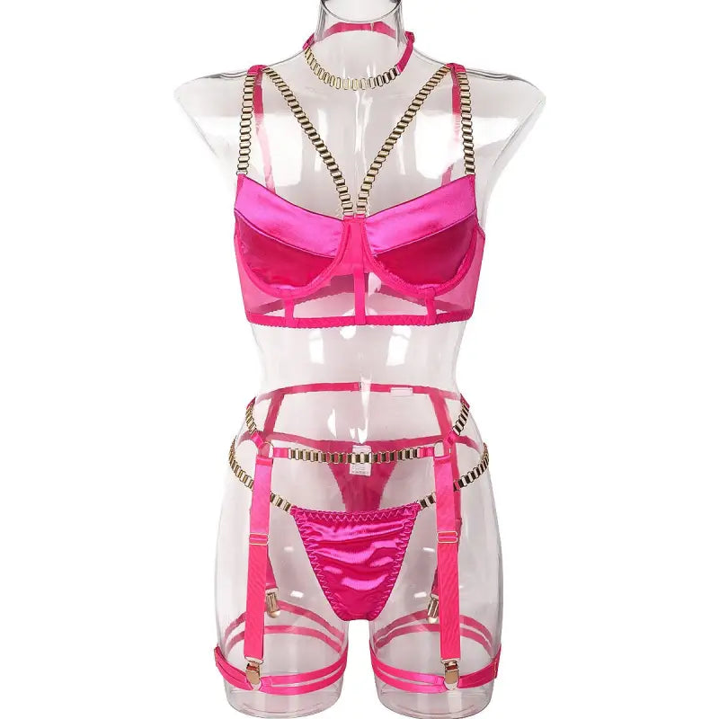 Hot pink lingerie set with chain four piece design on transparent mannequin torso