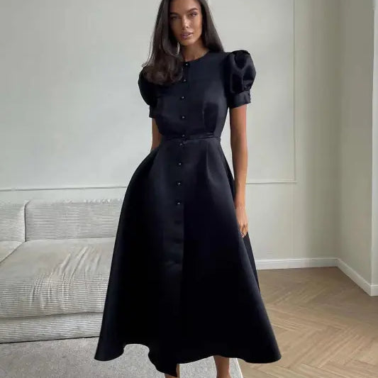 Elegant woman in a black midi swing line dress with puff sleeves and sparkly shoes