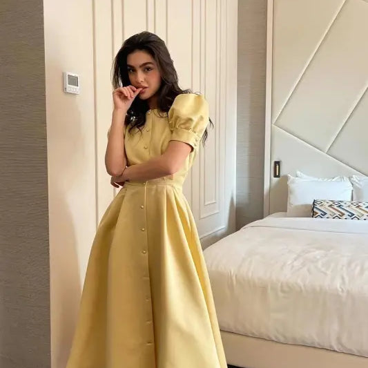 Yellow midi dress with puff sleeves and button-down front, perfect as a large swing line dress