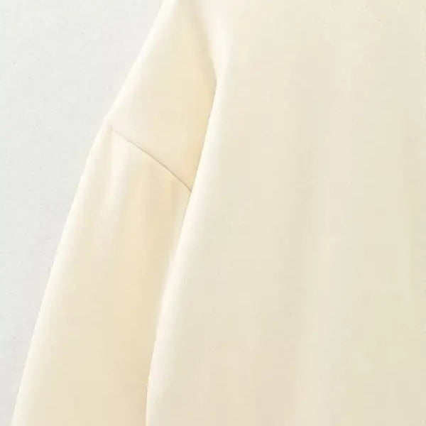 Cream-colored cute pattern sweater featuring a round neckline and dropped shoulder seam