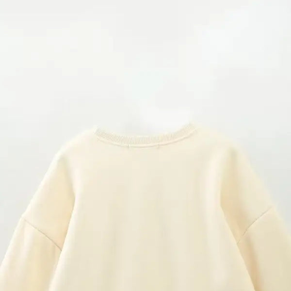 Cream-colored cute pattern sweater featuring a round neckline for girls’ clothing