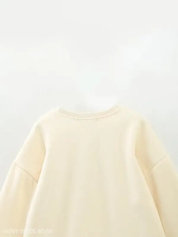 Cream-colored cute pattern sweater featuring a round neckline for girls’ clothing
