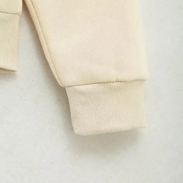 Cream-colored fabric sleeve cuff with ribbed knit detail on Cute Pattern Sweater