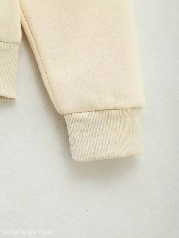Cream-colored fabric sleeve cuff with ribbed knit detail on Cute Pattern Sweater