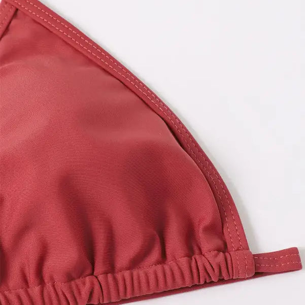 Coral-colored triangle bikini top with elastic gathering along the bottom edge.