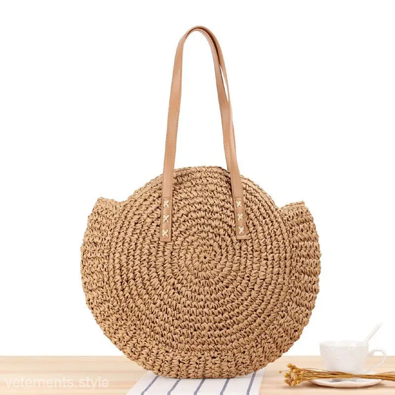 Circular woven straw handbag with tan leather straps for a large striped blue cross bohemian bag
