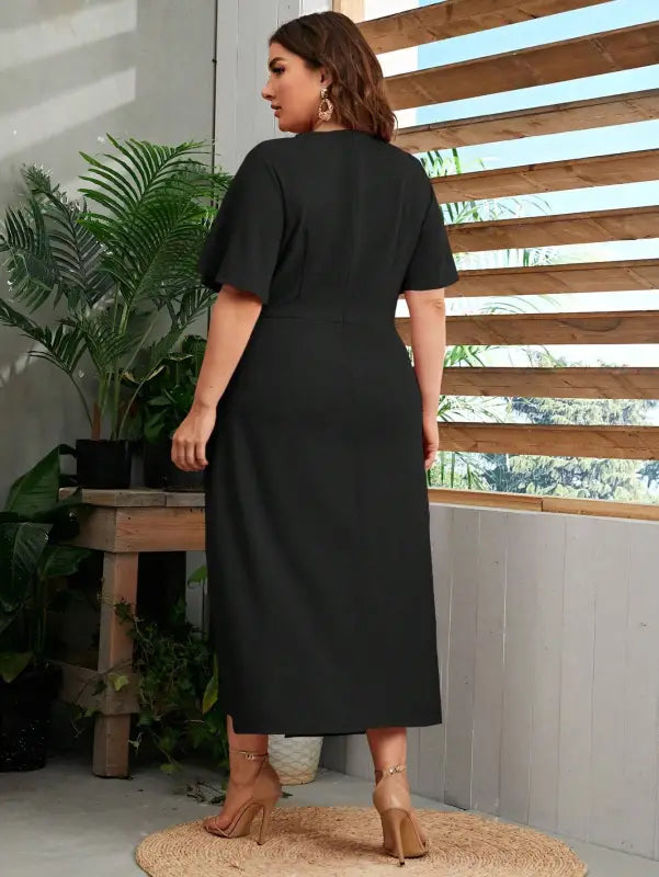 Black line midi dress with short sleeves worn by a woman facing away from the camera