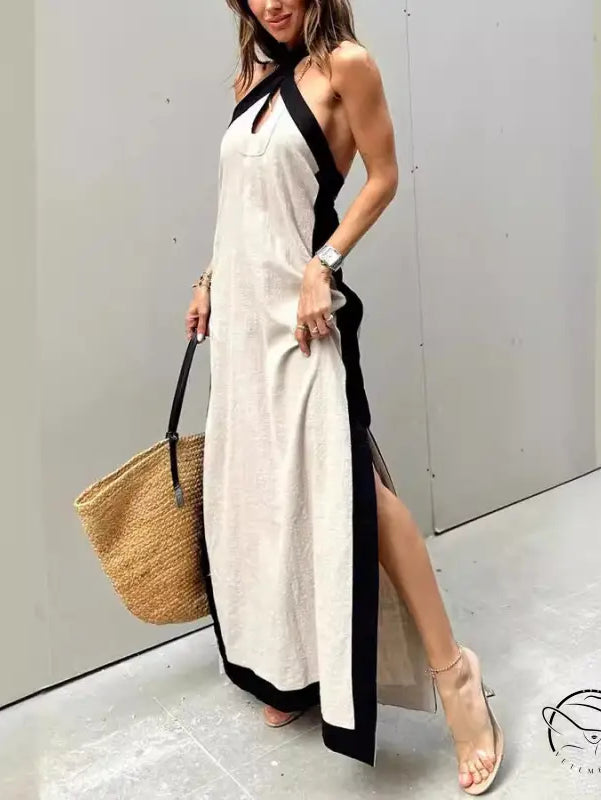 Long white halter dress with black trim and side slit.
