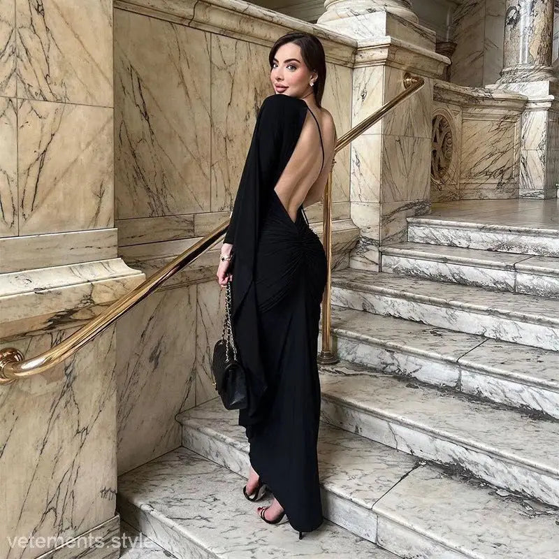 Woman in a sexy low cut backless evening dress on elegant marble stairs