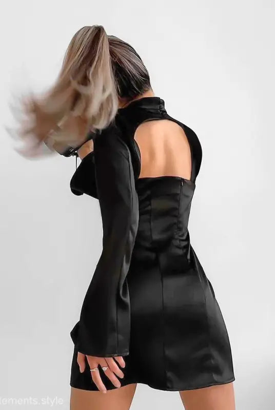 Elegant black short dress with long trumpet sleeves and open back for formal occasions