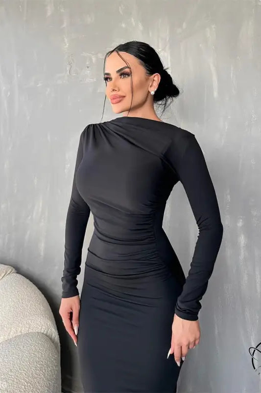 Woman wearing an elegant bodycon dress in black with her hair in a bun