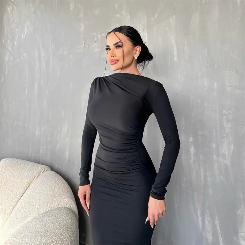Woman wearing an elegant bodycon dress in black with her hair in a bun