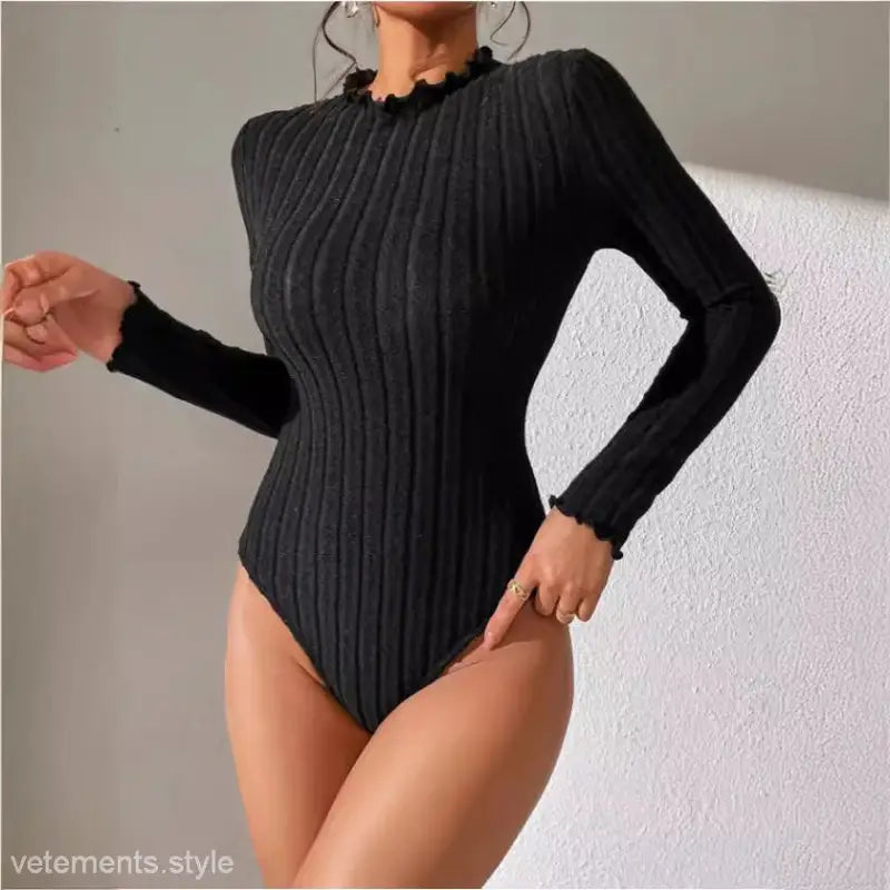 Black ribbed long-sleeve bodysuit with ruffled neckline, perfect for brushed striped jumpsuit styling